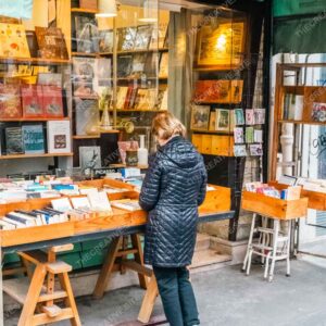 Browsing Books Outside Vintage Parisian Bookshop Wall