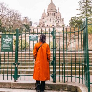 Person In Orange Coat Facing Sacre Coeur Gates