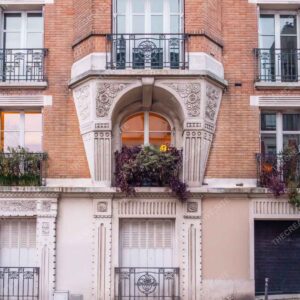 Paris Red Brick Facade With Ornate Balcony And Flowers