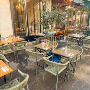 Parisian Outdoor Café With Olive Tree And Modern Woven Chairs